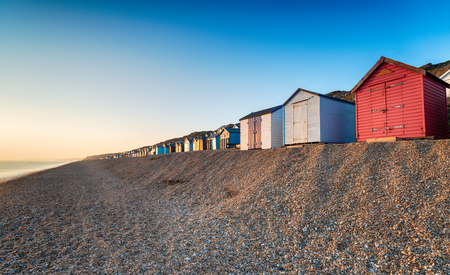 A row of colourful beach huts on a shingle beach at Milford on Sea on the Hampshire coastの写真素材