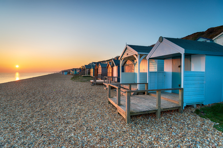 Beautiful sunset over a row of colourful beach huts at Milford on Sea on the Hampshire coastの写真素材