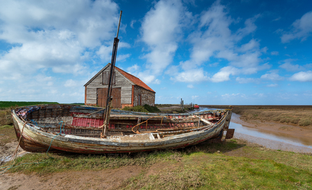 An old fishing boat at the Old Harbour at Thornham on the Norfolk coastの写真素材