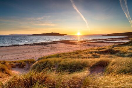 Sunset over the dunes at Big Sand Beah at Gairloch in the Highlands of Scotland, looking out to...