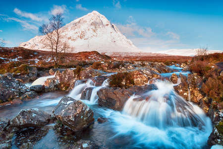 Snow topped mountains and waterfalls at Glen Etive in the Highlands of Scotlandの写真素材