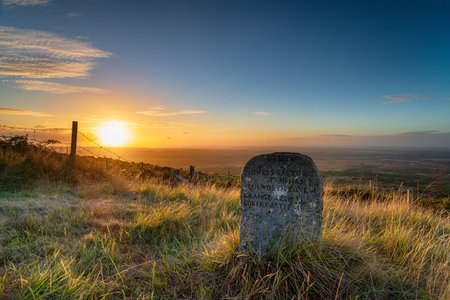 Sunset over a waymarker stone on the Lulworth ranges near Tyneham in the Purbeck Hills in Dorsetの写真素材