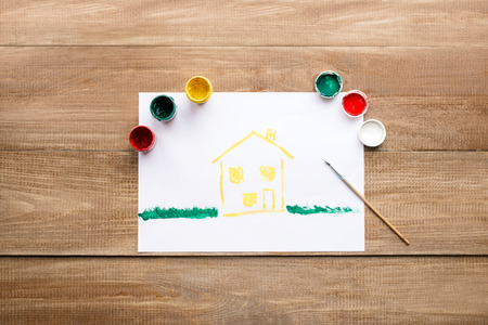 on a wooden table lie paints and drawing at homeの写真素材