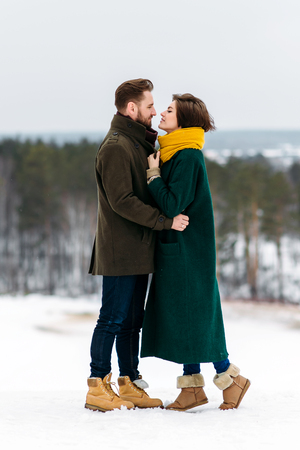 the beautiful loving couple walks in the winter outdoorsの写真素材