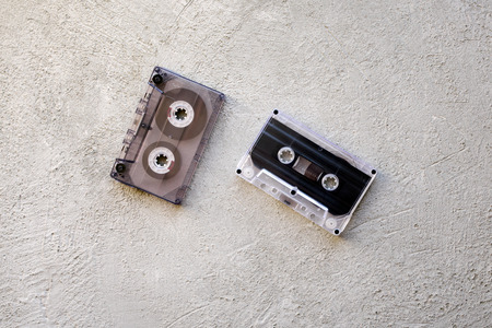two old audio cassettes on a concrete backgroundの写真素材