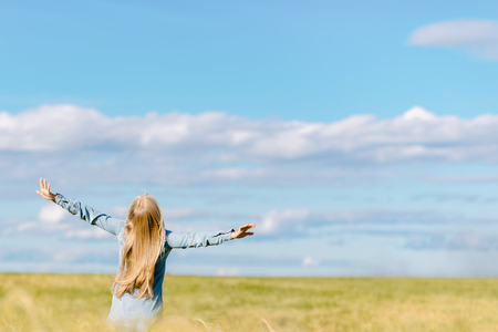 the happy girl runs with wheat across the fieldの写真素材