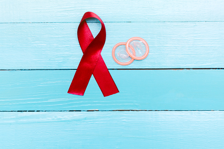 red ribbon and condoms on blue board