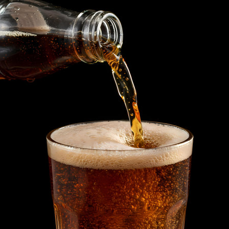 Pouring beer into a glass on a black background, close-upの素材