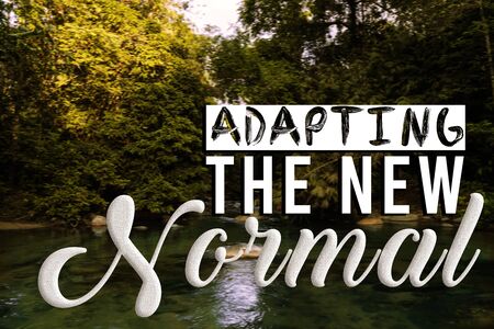 ADAPTIVE THE NEW NORMAL text on a blurred out forest. New normal after pandemic. Corona Virus outbreak concept.の写真素材