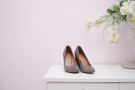Kuala Lumpur, Malaysia - March 16, 2020: Malay Wedding, beautiful of dark grey high heels for the bride on the white cabinet, and pink backgroundのeditorial素材