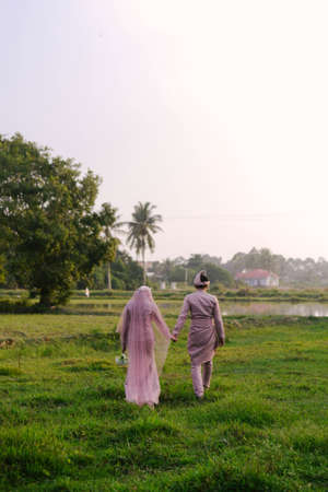 Kuala Lumpur, Malaysia - February 16, 2020: Malay Wedding Couple Bride and Groom holding hands and walking with full of the heart during the wedding day.のeditorial素材