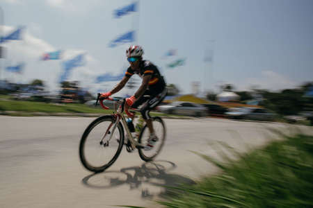 Kuala Lumpur, Malaysia- December 2019 - Panning blurred motion shot of commuter on a bicycle. A man cycling wearing a black cycling jerseyのeditorial素材