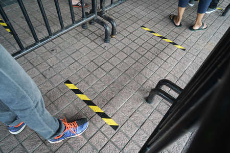 Kuala Lumpur, Malaysia - May 14, 2020: New normal lifestyle, people line up one meter social distancing gap between each other to stop the COVID-19 from spreading also wearing mask for safety.のeditorial素材