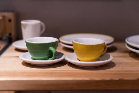 Green and yellow small cup on the table. Image contains excessive noiseの写真素材