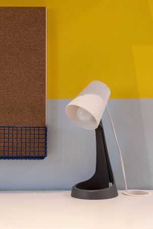 Outstanding table lamp on the table with the yellow background. Image contains excessive noiseの写真素材