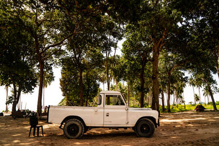 September 25, 2020: Pulau Redang Terengganu, Malaysia: White Land Rover Defender under the tree beside the seaのeditorial素材