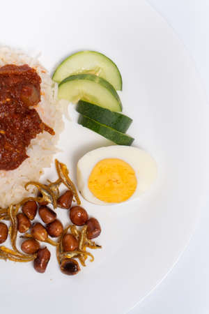 Top angle of Nasi Lemak-Malaysian cuisine. A fragrant rice dish cooked in coconut milk and pandan leaf commonly found in Malaysia. Served with sambal, anchovies, peanut, and cucumber.の写真素材