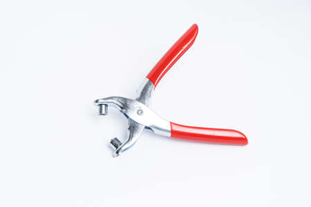 Red rivet puncher, riveting pliers close-up on a white background. Puncher and grommet installer. Tool for installing the eyelet. Isolated objectの写真素材
