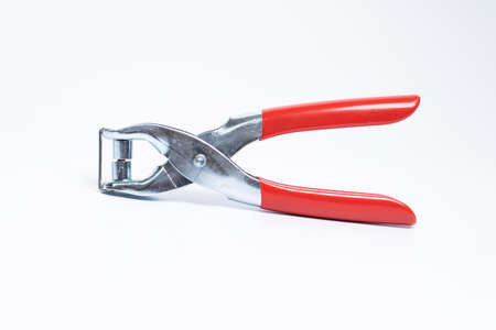 Red rivet puncher, riveting pliers close-up on a white background. Puncher and grommet installer. Tool for installing the eyelet. Isolated objectの写真素材