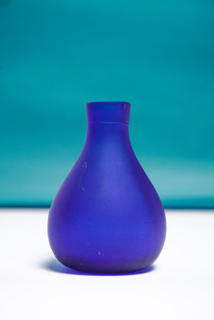 Blue curved vase on dark green and white backgroundの写真素材