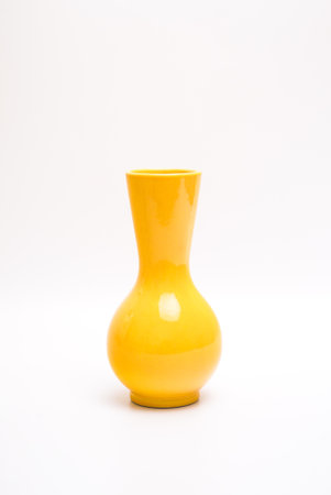 Yellow curved vase for interior decoration. Studio shot and isolated on white backgroundの写真素材