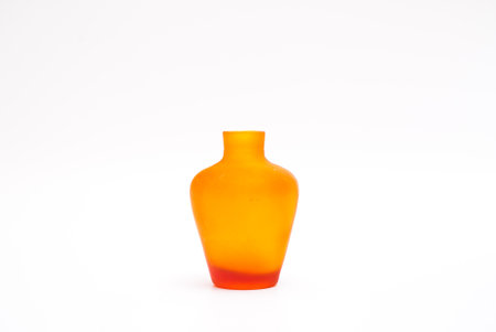 Transparent orange curved vase for interior decoration. Studio shot and isolated on white backgroundの写真素材