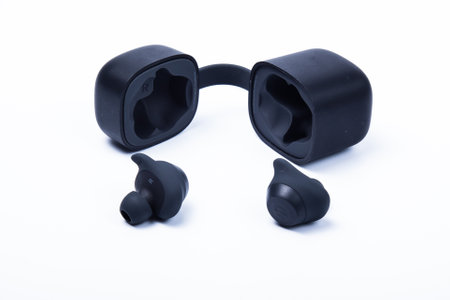 The black wireless earbud headphones and the case. Isolated on white backgroundの写真素材
