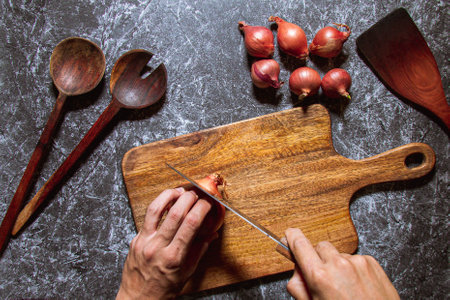 The cook cuts the onion on a cutting boardの写真素材