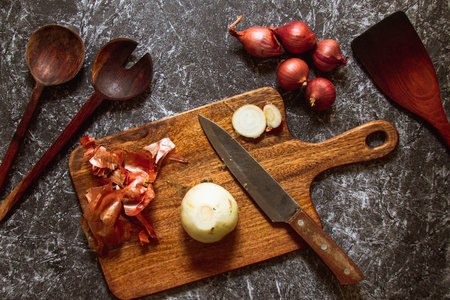 A Onion And A Knife On A Wooden Chopping Boardの写真素材