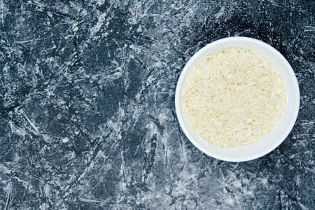 A long grain white rice, on concrete pattern wall background. Copy spaceの写真素材