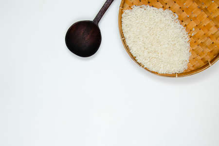 A long grain white rice, on rattan handmade bowl with wooden spoon isolated on white background. Copy spaceの写真素材