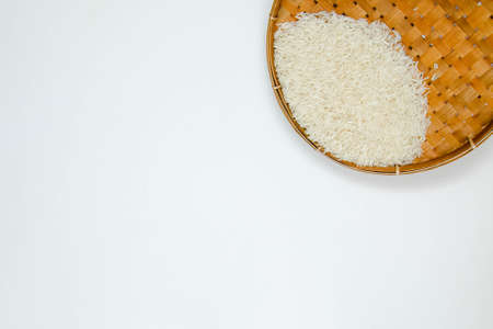 A long grain white rice, on rattan handmade bowl isolated on white background. Copy spaceの写真素材