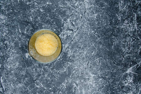 Brown sugar in transparent cup. On concrete pattern wall background. Copy spaceの写真素材