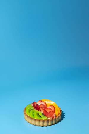 puff pastry pie with fresh fruits. Hand holding slice of strawberryの写真素材