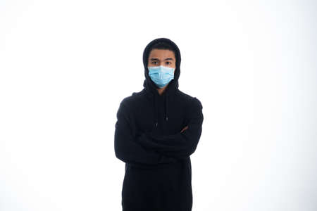 health, pandemic and safety concept - asian young man wearing face protective medical mask for protection from virus disease over white backgroundの写真素材