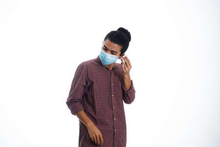 health, pandemic and safety concept - asian young man wearing face protective medical mask for protection from virus disease over white backgroundの写真素材