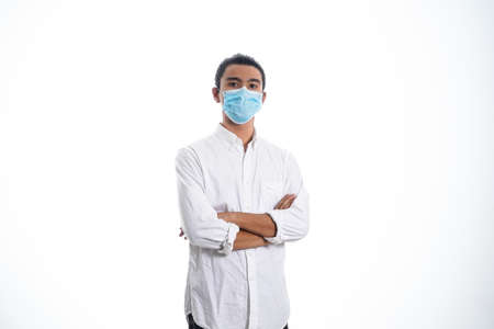 health, pandemic and safety concept - asian young man wearing face protective medical mask for protection from virus disease over white backgroundの写真素材