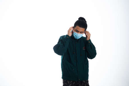 health, pandemic and safety concept - asian young man wearing face protective medical mask for protection from virus disease over white backgroundの写真素材