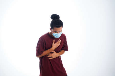 the concept of health care and medicine. A young man standing in a face mask with hand gesture "i'm sick", supporting social distanceの写真素材