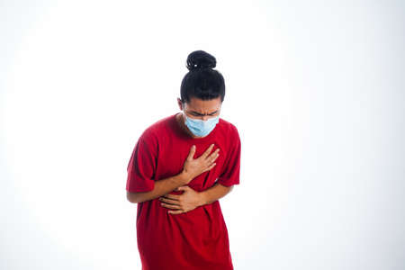 the concept of health care and medicine. A young man standing in a face mask with hand gesture "i'm sick", supporting social distanceの写真素材