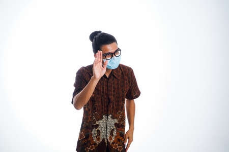 health, pandemic and safety concept - asian young man wearing face protective medical mask for protection from virus disease over white backgroundの写真素材