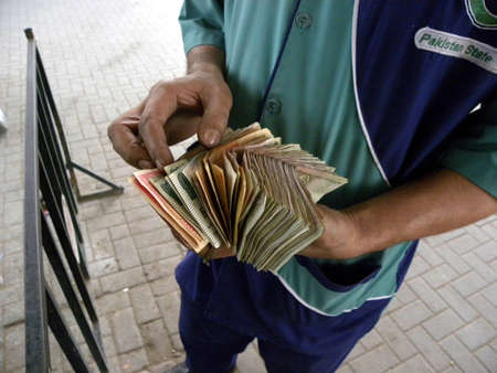 LOCAL_PETROL_PUMP_CASHIER_COUNTING_MONEY TODAY ON THURSDAY_15/3/2012_KARACHI/PAKISTAN                              のeditorial素材
