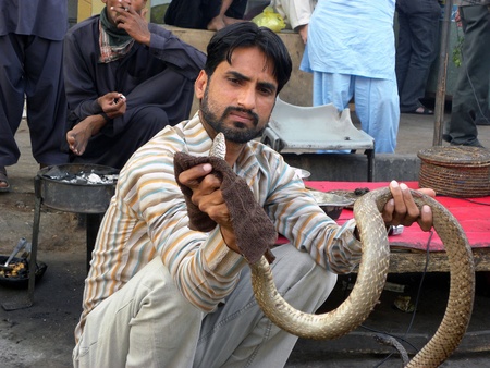 PAKISTAN/KARACHI_LOCAL SNAKE CHARMER SHOWING SNAKE IN FRONT OF PEOPLE TODAY ON THURSDAY 29 MARCH 2012                        のeditorial素材