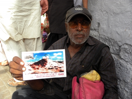 PAKISTAN/KARACHI_OLD MAN SHOWING VERY OLD PICTURE OF ABDULLAH SHAH GHAZI MAZAR.THE PICTURE SHOWのeditorial素材