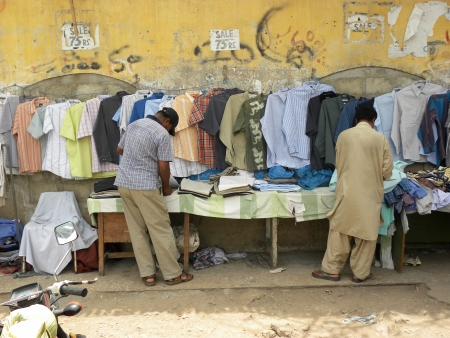 PAKISTAN/KARACHI_LOCAL PEOPLE CHECKING SHIRTS FROM FOOTPATH STALL TRYING TO BUY LOW PRICE SHIRTS ARE USED SHIRT TODAY ON FRIDAY 22 JUNE 2012                                                  のeditorial素材