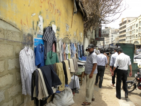PAKISTAN/KARACHI_LOCAL PEOPLE CHECKING SHIRTS FROM FOOTPATH STALL TRYING TO BUY LOW PRICE SHIRTS ARE USED SHIRT TODAY ON FRIDAY 22 JUNE 2012                                                                            のeditorial素材