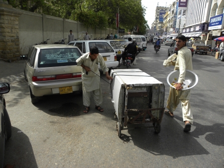 PAKISTAN/KARACHI_YOUNG BOY FASTEN TIED-UP REFRIGERATOR WITH ROPE ON HIS HAND CART FOR TAKING REFRIGERTOR TO HIS SHOP TODAY ON SUNDAY 1 JULY 2012 (PHOTO BY ZAHID RANA/DEAN PICTURES)                                  のeditorial素材