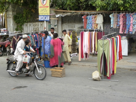 PAKISTAN/KARACHI_PAKISTANI YOUNG FEMALES BUYING FASHINABLE DRESSES FROM STALL SHOP TODAY ON FRIDAY 20 JULY 2012 IN KARACHI                                 のeditorial素材