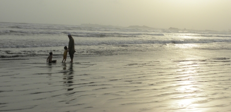 PAKISTAN/KARACHI_A LOCAL FATHER ENJOYING UP COMING SEA WAVES WITH HIS CHILDREN TODAY ON THUESDAY 28 AUGUST 2012. AT KARACHI SEA VIEW                                のeditorial素材