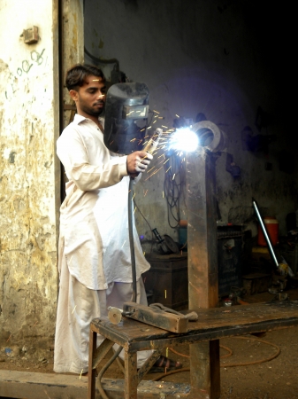 PAKISTAN/KARACHI_WELDER WITH PROTECTIVE MASK WELDING METAL AND SPARKS TODAY ON SUNDAY 16 SEPTEMBER 2012 IN KARACHI                                のeditorial素材